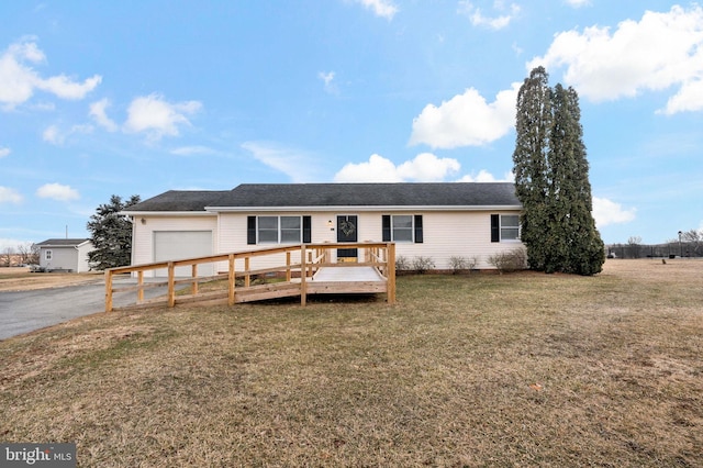 ranch-style house featuring an attached garage, a deck, and a front lawn