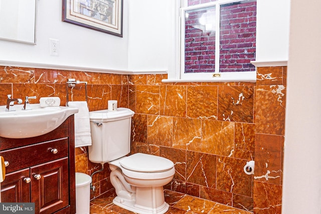 bathroom featuring toilet, tile walls, and vanity