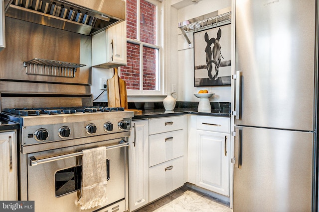 kitchen featuring stainless steel appliances, dark countertops, custom range hood, and white cabinetry