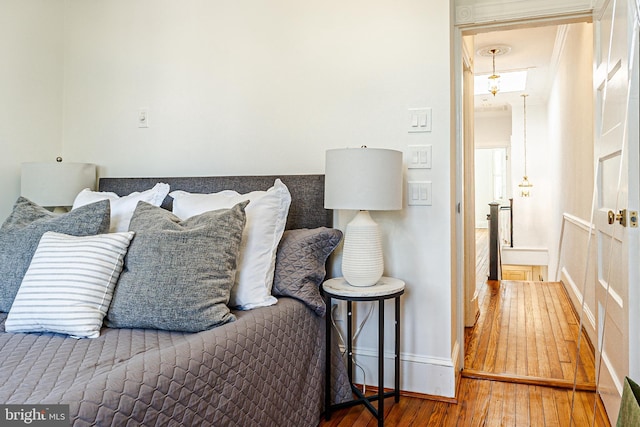 bedroom featuring wood finished floors and baseboards