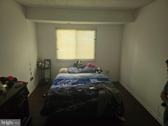 bedroom featuring dark wood finished floors and baseboards