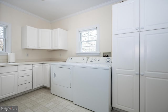 clothes washing area featuring ornamental molding, separate washer and dryer, cabinet space, and a healthy amount of sunlight