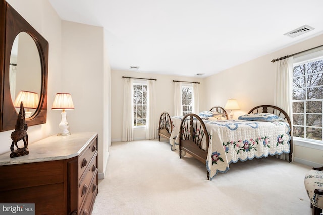 bedroom featuring light colored carpet, visible vents, and baseboards