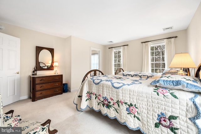 carpeted bedroom featuring visible vents and baseboards