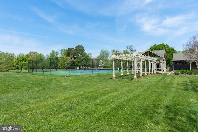 view of yard with a tennis court, fence, and a pergola