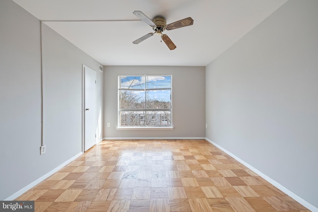 empty room featuring visible vents, ceiling fan, and baseboards