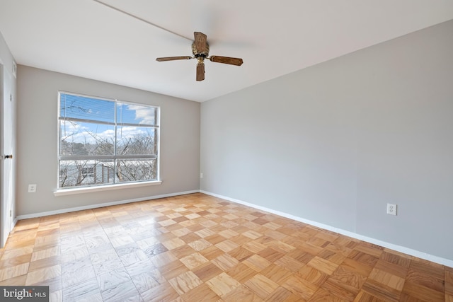 spare room with baseboards and a ceiling fan