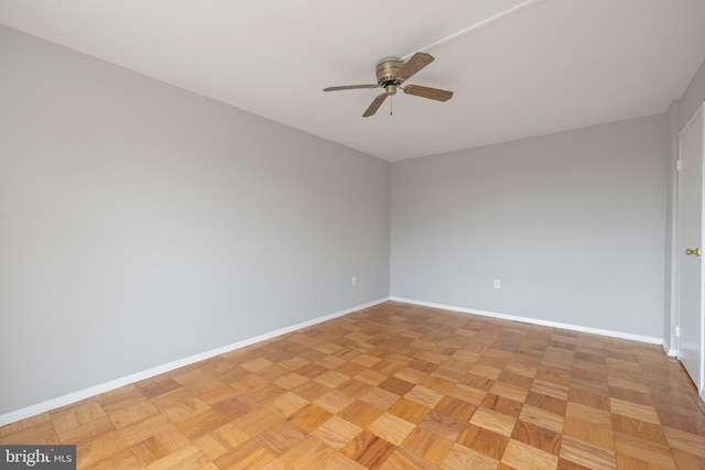 spare room featuring ceiling fan and baseboards