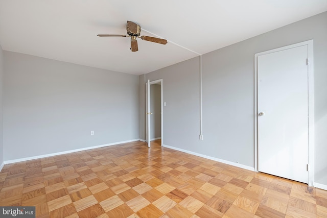 unfurnished room with a ceiling fan and baseboards