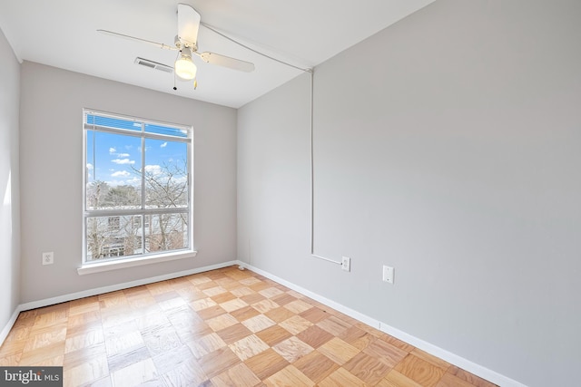 empty room with visible vents, ceiling fan, and baseboards