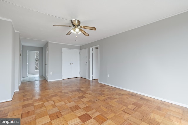 unfurnished room featuring ceiling fan, baseboards, and ornamental molding