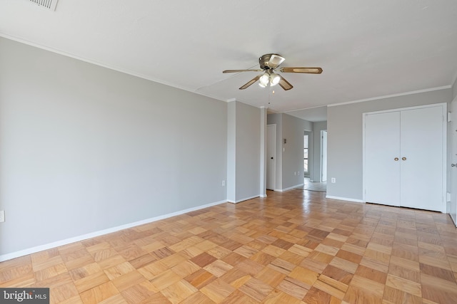 empty room with ceiling fan, ornamental molding, and baseboards