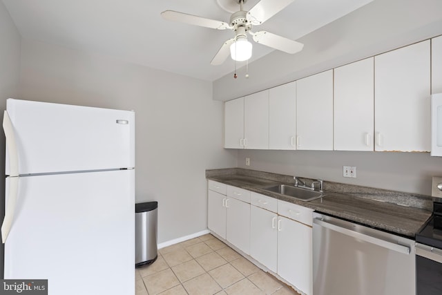 kitchen with dark countertops, white cabinetry, stainless steel appliances, and a sink