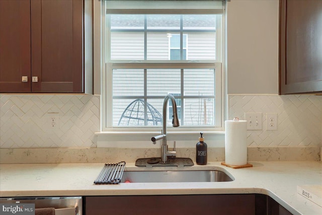 kitchen with stainless steel dishwasher, plenty of natural light, decorative backsplash, and a sink