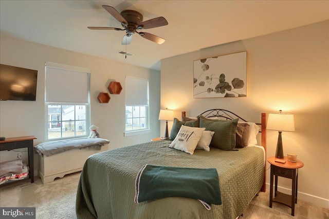 bedroom with light carpet, a ceiling fan, visible vents, and baseboards