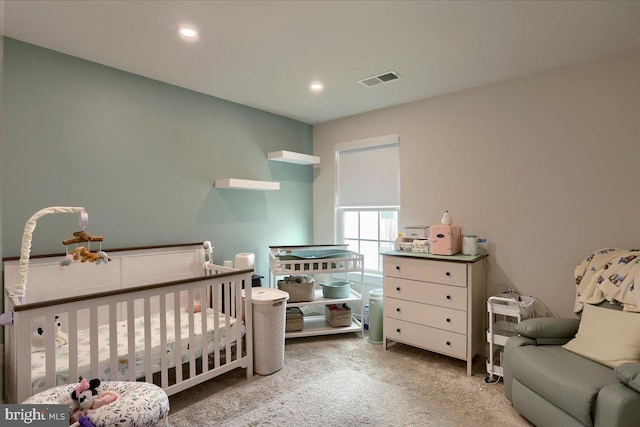 carpeted bedroom featuring a nursery area, visible vents, and recessed lighting