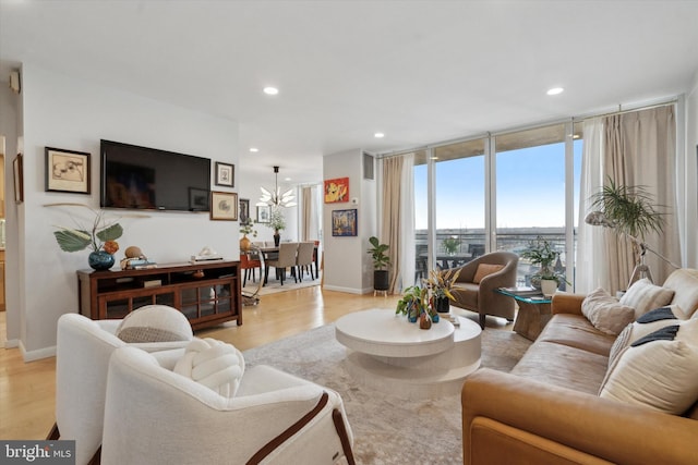 living area with recessed lighting, baseboards, floor to ceiling windows, and light wood finished floors