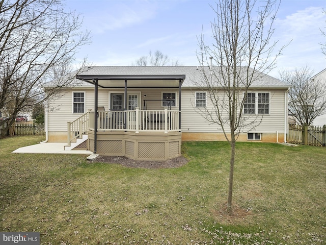 back of house featuring a shingled roof, a patio, a yard, fence, and a wooden deck