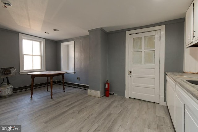 dining area with light wood-style flooring and baseboards