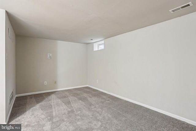 spare room with carpet, visible vents, and baseboards