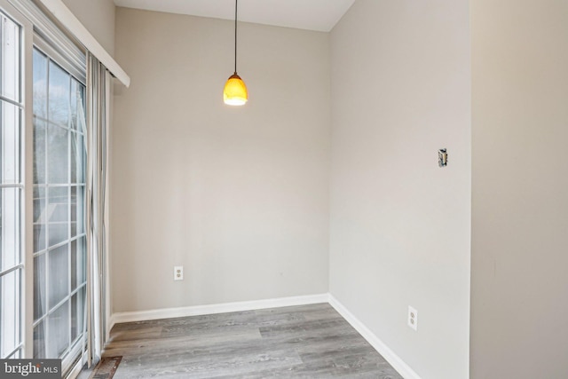 unfurnished dining area featuring visible vents, baseboards, and wood finished floors