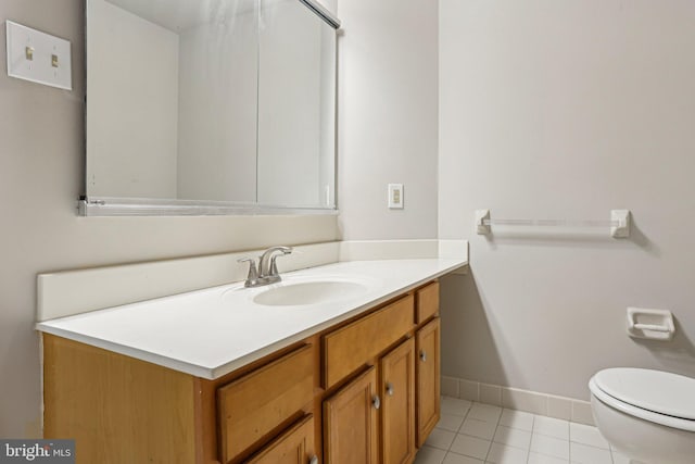 bathroom featuring toilet, tile patterned flooring, baseboards, and vanity