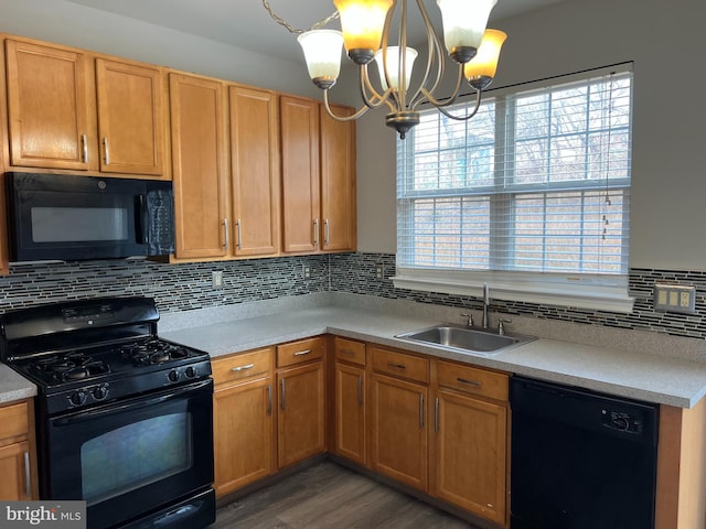 kitchen featuring dark wood finished floors, decorative backsplash, an inviting chandelier, a sink, and black appliances