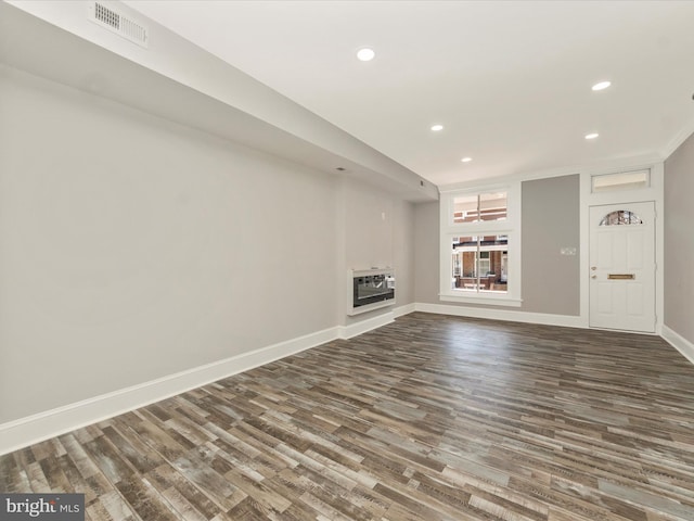 unfurnished living room featuring visible vents, baseboards, dark wood finished floors, and a fireplace