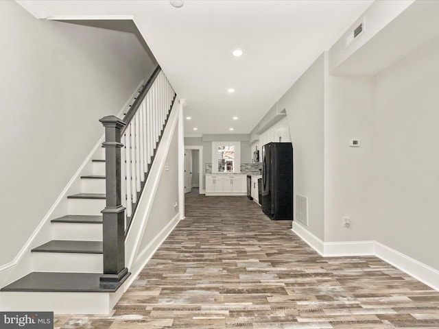 entryway featuring visible vents, baseboards, stairs, recessed lighting, and wood finished floors