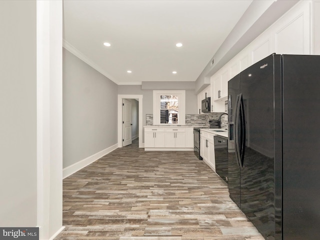 kitchen featuring baseboards, white cabinetry, black appliances, and light countertops