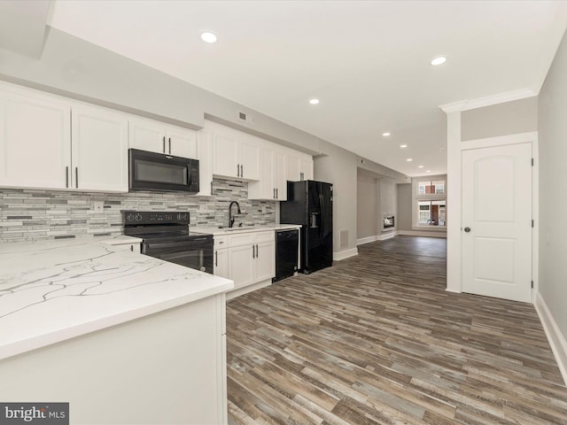 kitchen with black appliances, backsplash, wood finished floors, white cabinets, and light stone countertops