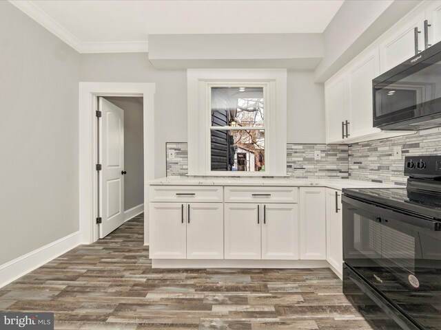 kitchen featuring white cabinetry, black appliances, wood finished floors, and tasteful backsplash