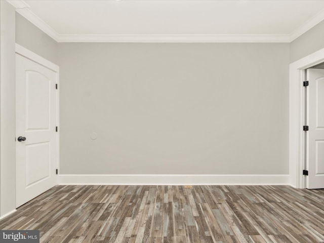 unfurnished room featuring ornamental molding, baseboards, and wood finished floors