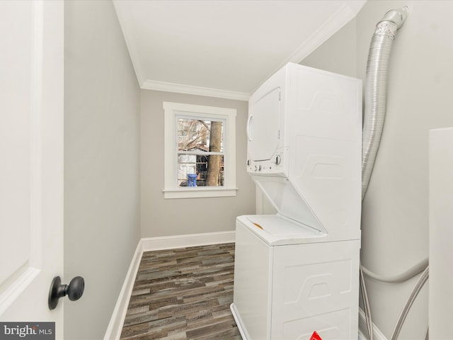 washroom with dark wood-style floors, stacked washing maching and dryer, crown molding, baseboards, and laundry area