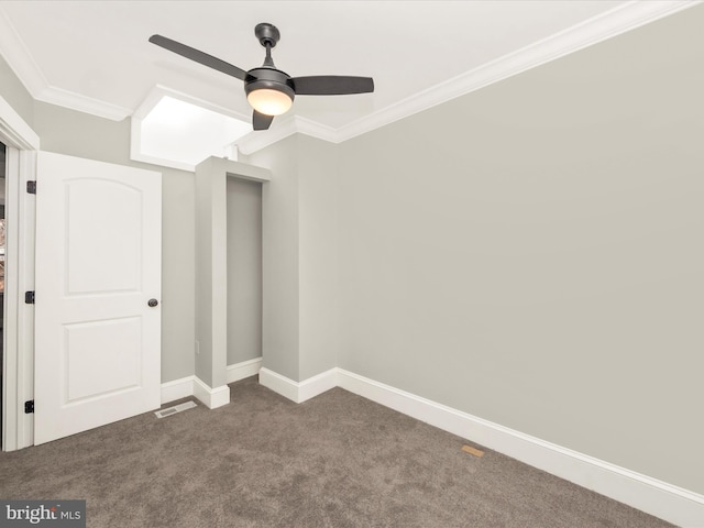 unfurnished bedroom with dark carpet, a ceiling fan, crown molding, and baseboards