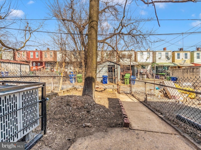 view of yard with an outbuilding, fence, and a residential view