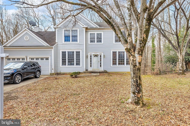 view of front of property featuring concrete driveway, a chimney, and an attached garage