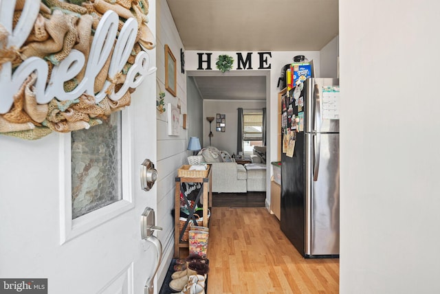 interior space featuring freestanding refrigerator, white cabinetry, and light wood finished floors