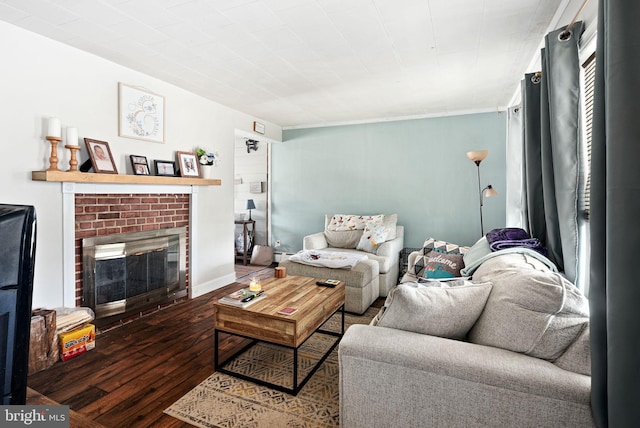 living area featuring a brick fireplace and wood finished floors