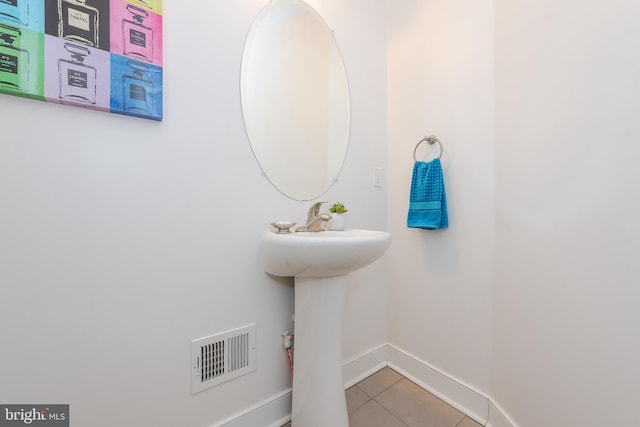 bathroom with baseboards, a sink, visible vents, and tile patterned floors