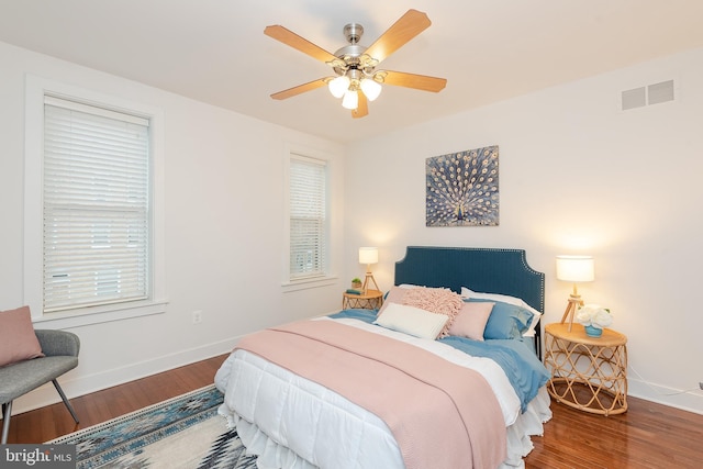 bedroom with dark wood-style floors, baseboards, and visible vents