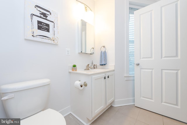 bathroom featuring toilet, tile patterned flooring, baseboards, and vanity