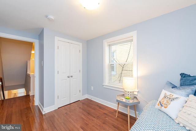 bedroom featuring a closet, wood finished floors, and baseboards