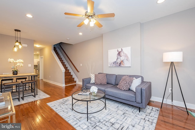 living room with stairway, recessed lighting, wood finished floors, and baseboards