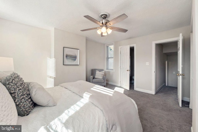 bedroom with baseboards, a textured ceiling, dark carpet, and a ceiling fan