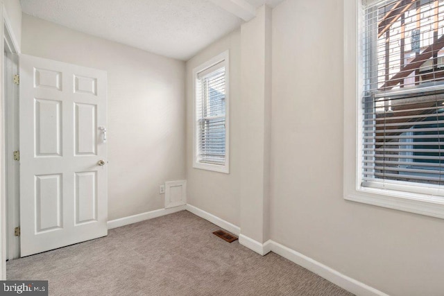 unfurnished room with light colored carpet, visible vents, and baseboards