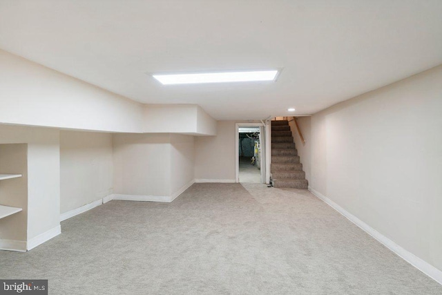 finished below grade area featuring stairs, recessed lighting, baseboards, and light colored carpet