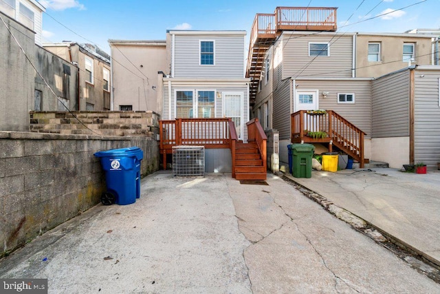 back of house with central AC and stairway