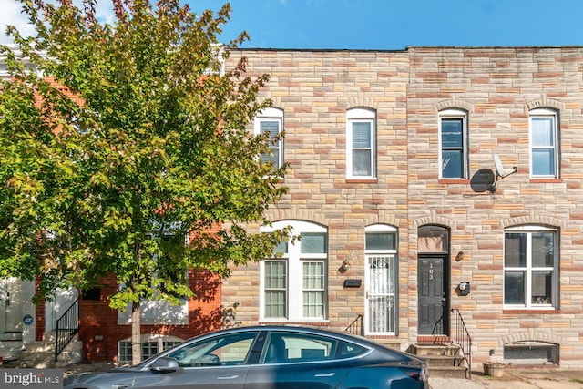 townhome / multi-family property with entry steps and stone siding