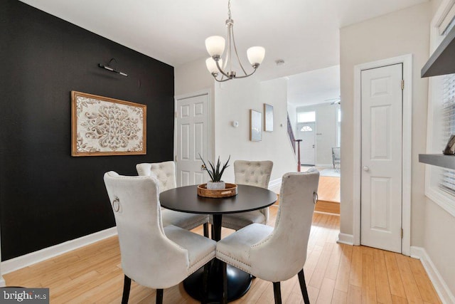 dining room featuring an inviting chandelier, light wood-style flooring, and baseboards